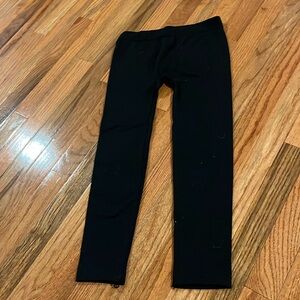 Plain black pants with a little string at the bottom which can be cut off